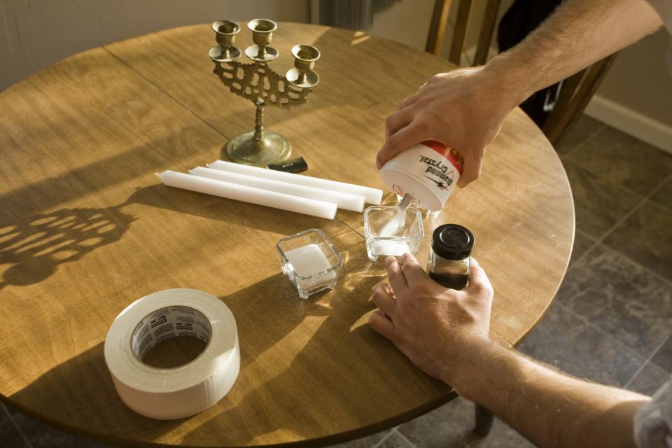 detail of table and artist pouring salt into glass bowl