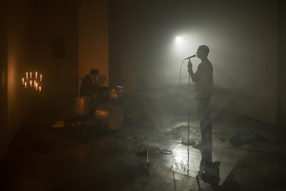 performer and drummer facing each other