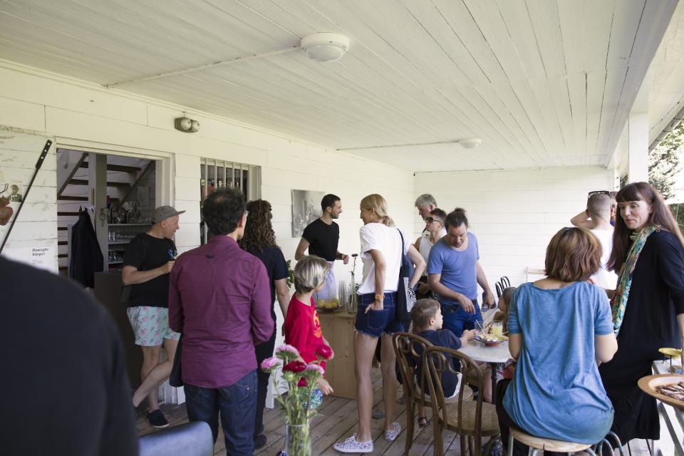 artist serving drinks to audience on veranda