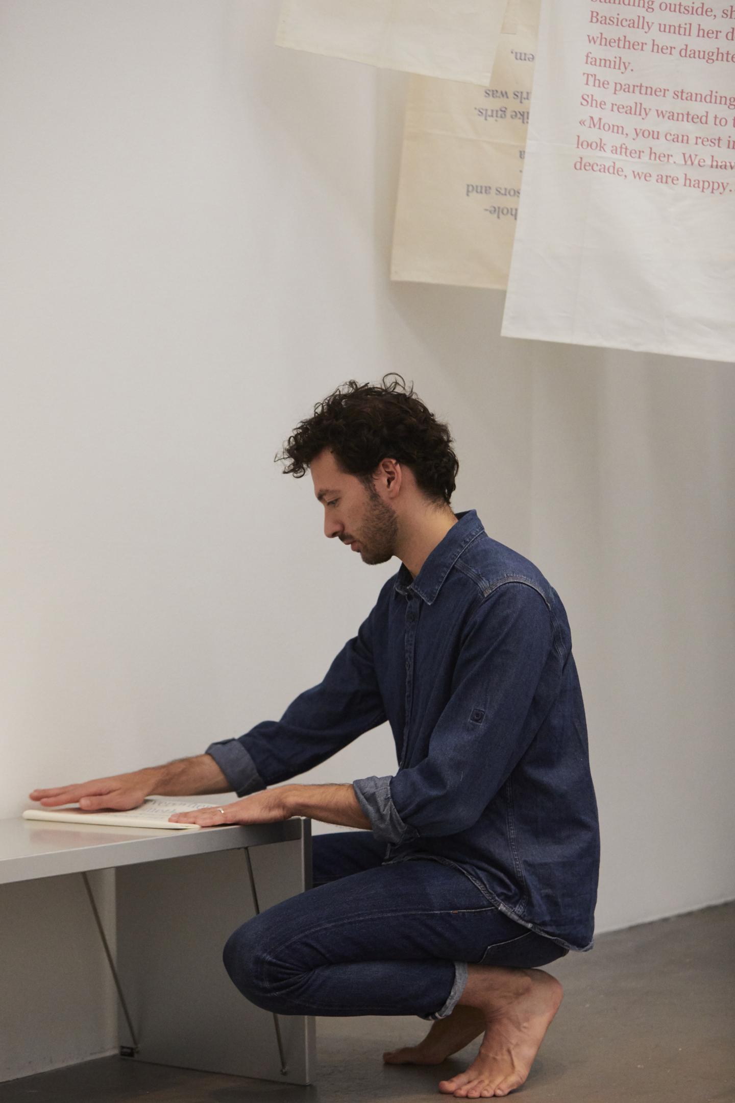 artist folds fabric on metal bench